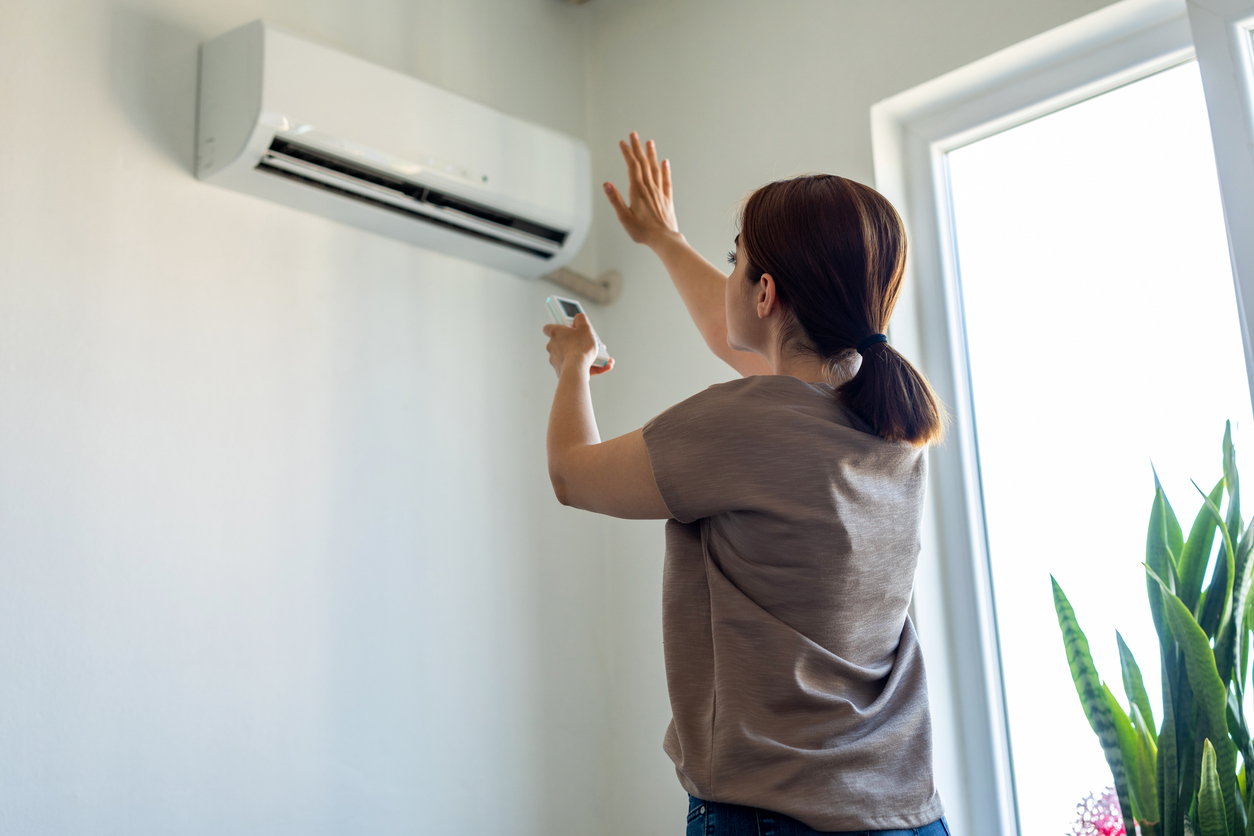 Woman turning on an A/C unit