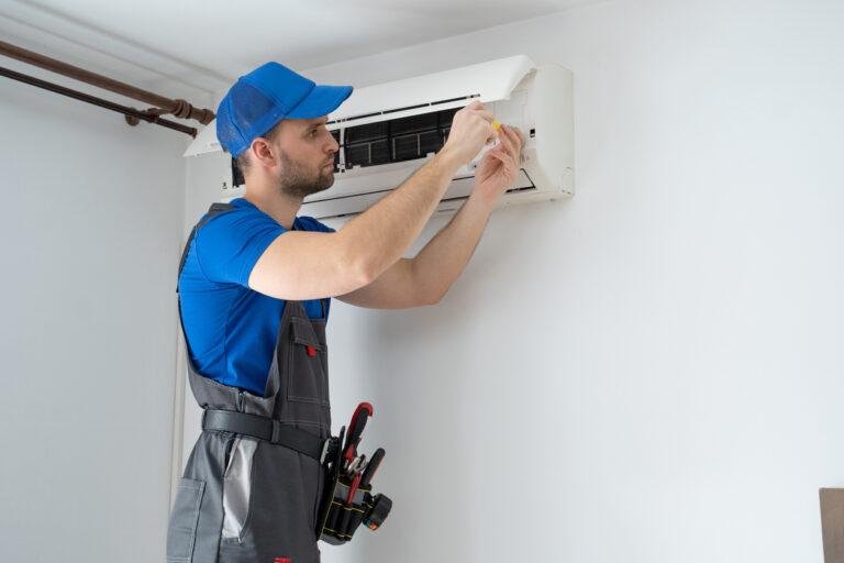 Avoid HVAC failure - an HVAC technician fixing an air conditioner unit.